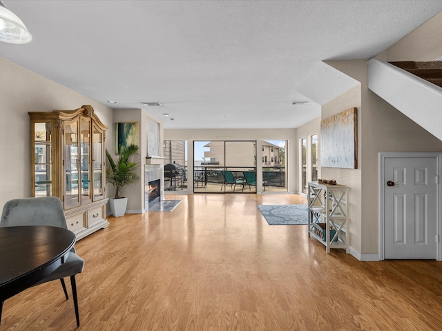 living room featuring light wood-type flooring and a fireplace