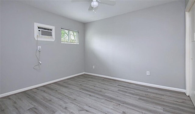 empty room with ceiling fan, light hardwood / wood-style floors, and a wall mounted air conditioner