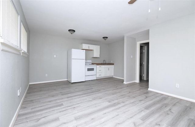 kitchen featuring white cabinets, white appliances, light hardwood / wood-style floors, and sink