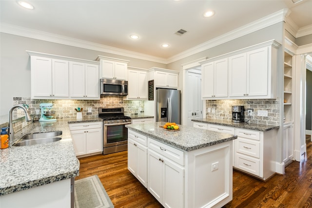 kitchen with white cabinets, a center island, dark wood-type flooring, stainless steel appliances, and sink