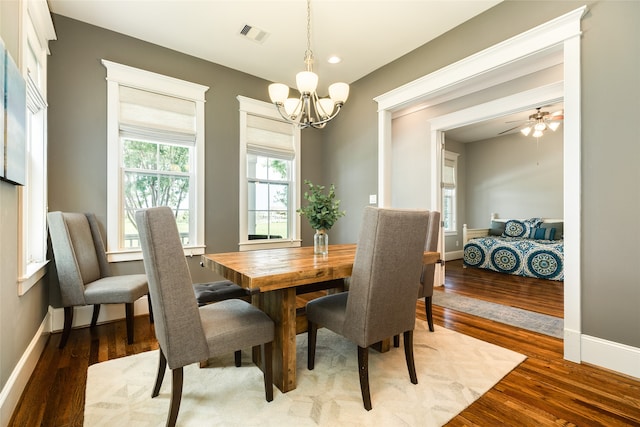 dining space featuring ceiling fan with notable chandelier and dark hardwood / wood-style flooring