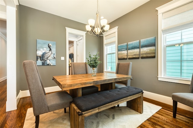 dining area with dark wood-type flooring and a chandelier