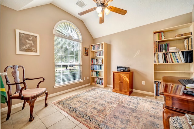 sitting room with ceiling fan, light tile patterned floors, and vaulted ceiling