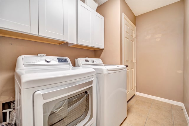 washroom featuring separate washer and dryer, cabinets, and light tile patterned floors