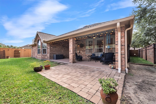 rear view of house featuring a lawn and a patio