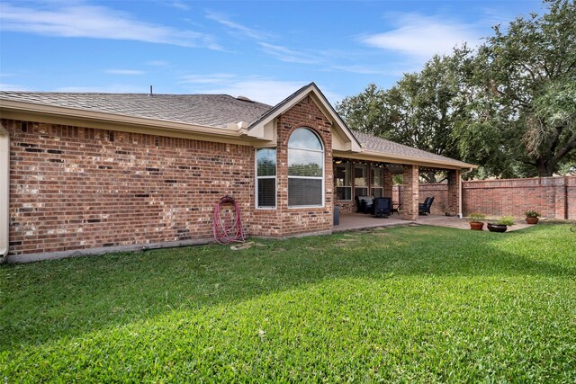 rear view of property featuring a lawn and a patio area