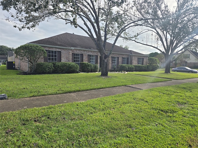 ranch-style home featuring cooling unit and a front yard