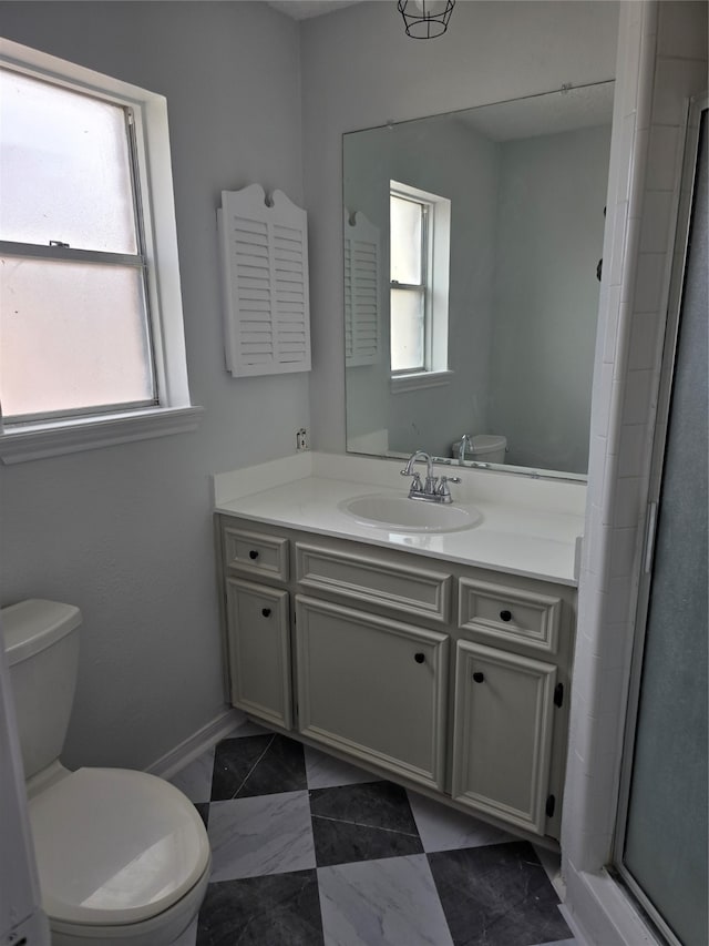 bathroom with a shower with door, vanity, and toilet