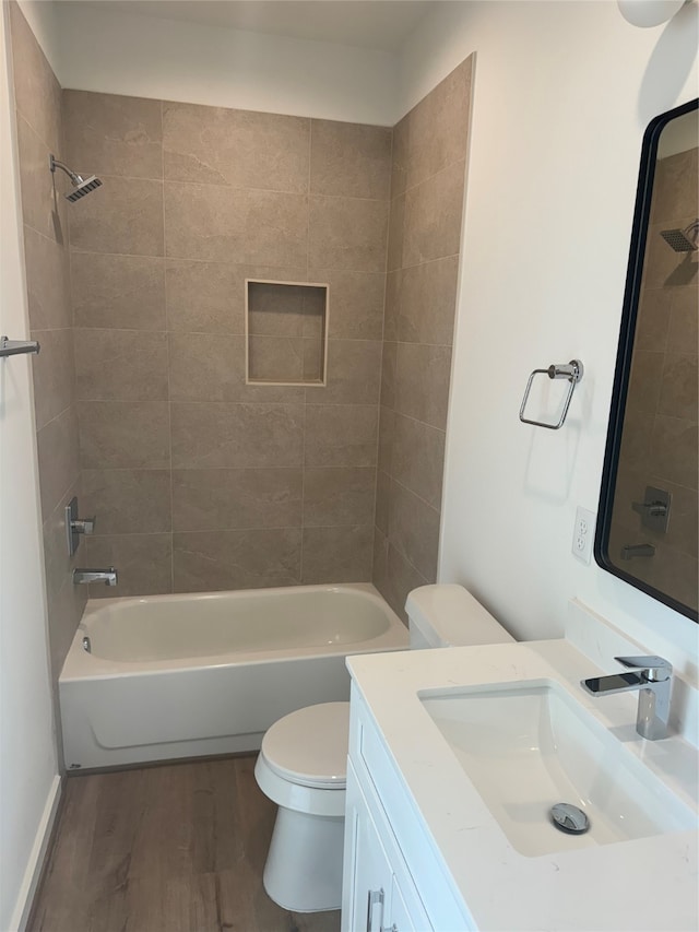 full bathroom featuring wood-type flooring, vanity, toilet, and tiled shower / bath