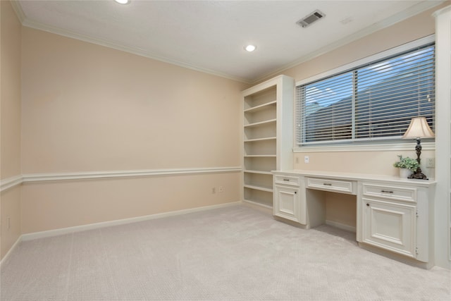 unfurnished office with ornamental molding, light carpet, and built in desk