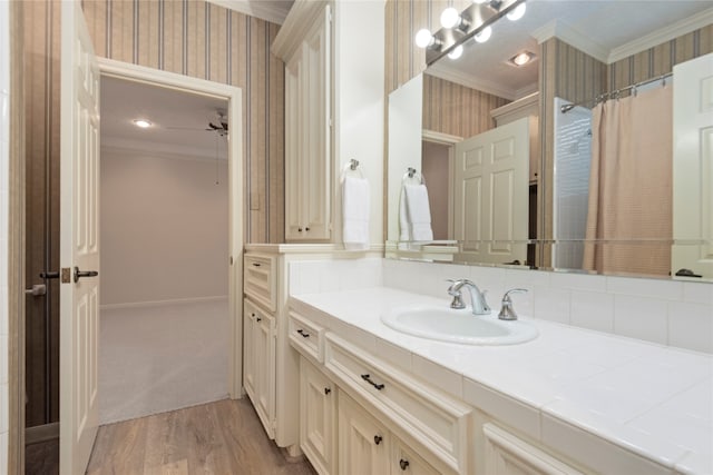 bathroom featuring a shower with shower curtain, backsplash, hardwood / wood-style floors, vanity, and crown molding