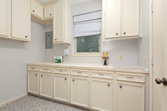 kitchen with electric panel and cream cabinetry