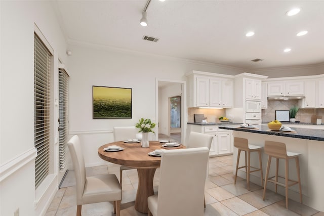 dining space featuring light tile patterned flooring and crown molding