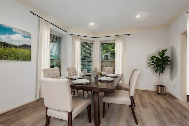 dining area with hardwood / wood-style floors and crown molding