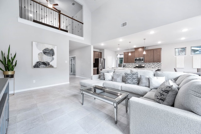 tiled living room with high vaulted ceiling and ceiling fan