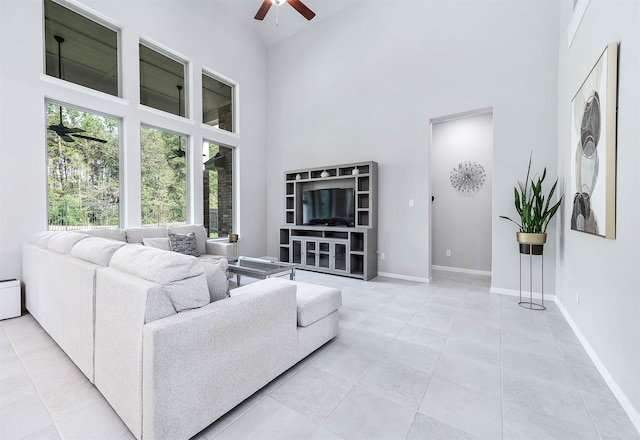 tiled living room with ceiling fan and high vaulted ceiling