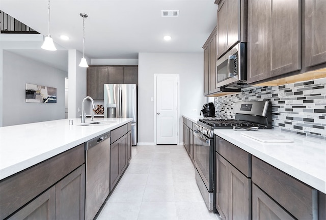 kitchen featuring dark brown cabinets, stainless steel appliances, sink, and pendant lighting