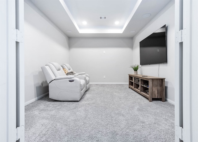 sitting room featuring carpet flooring and a raised ceiling