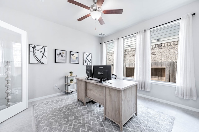 tiled home office featuring ceiling fan