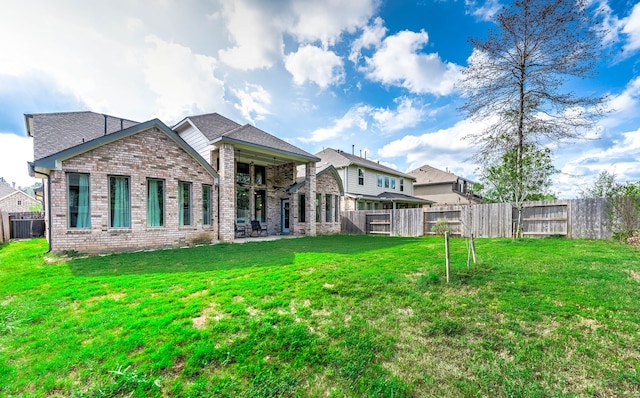 back of property with a patio, central AC, and a yard