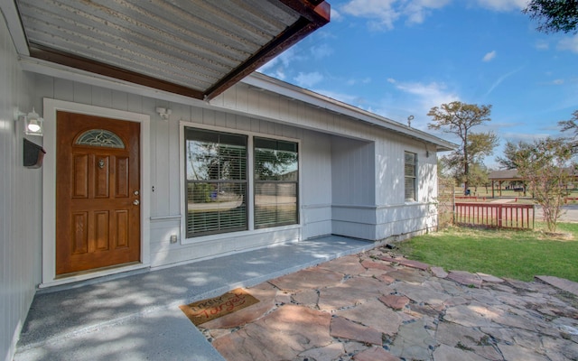 entrance to property featuring a yard and a patio