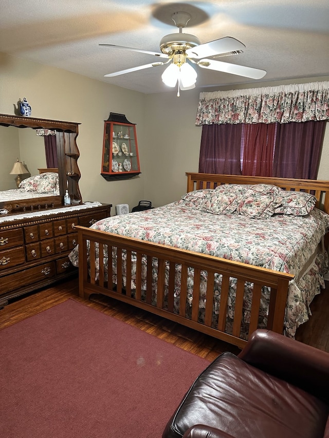 bedroom featuring a textured ceiling, ceiling fan, and dark hardwood / wood-style floors