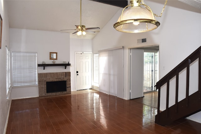 unfurnished living room featuring high vaulted ceiling, a fireplace, dark wood-type flooring, and ceiling fan