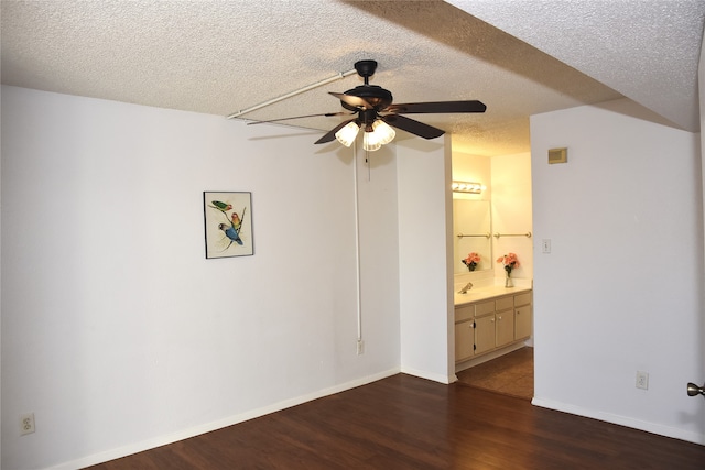 unfurnished bedroom with sink, ceiling fan, a textured ceiling, and dark hardwood / wood-style floors