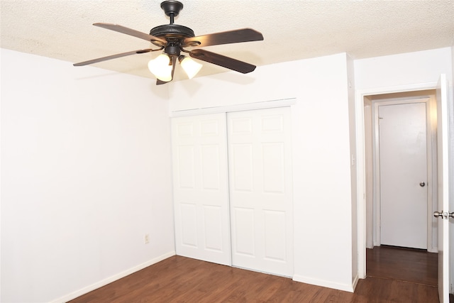 unfurnished bedroom with a closet, a textured ceiling, ceiling fan, and dark hardwood / wood-style floors