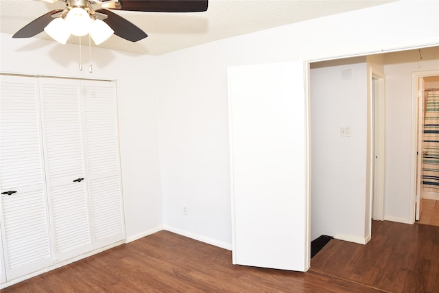 unfurnished bedroom featuring ceiling fan, a closet, and dark hardwood / wood-style flooring