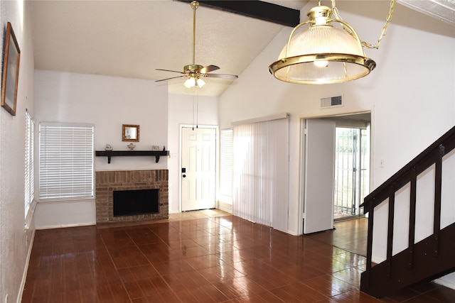 unfurnished living room with dark wood-type flooring, ceiling fan, high vaulted ceiling, and a brick fireplace