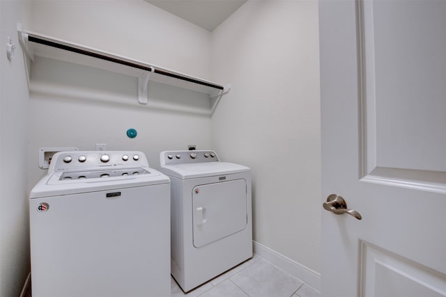 laundry area with washer and clothes dryer and light tile patterned floors