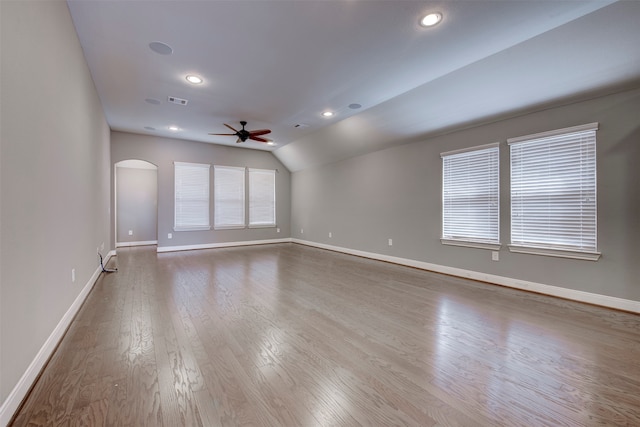 spare room featuring ceiling fan, wood-type flooring, and vaulted ceiling