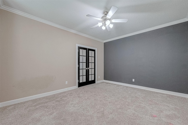 carpeted spare room with ceiling fan, ornamental molding, a textured ceiling, and french doors