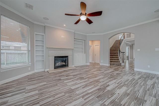 unfurnished living room featuring ceiling fan, light hardwood / wood-style floors, built in features, and crown molding