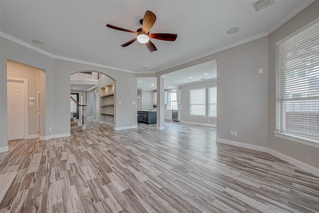 unfurnished living room featuring ceiling fan, light hardwood / wood-style floors, crown molding, and built in shelves