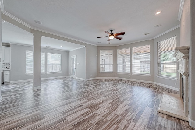 unfurnished living room featuring plenty of natural light, light hardwood / wood-style floors, ornamental molding, and ceiling fan