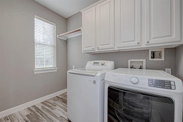 laundry room with cabinets, washer and clothes dryer, light hardwood / wood-style flooring, and a wealth of natural light