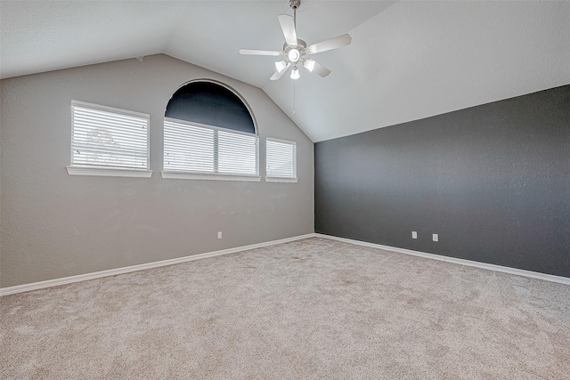 carpeted empty room featuring ceiling fan and vaulted ceiling