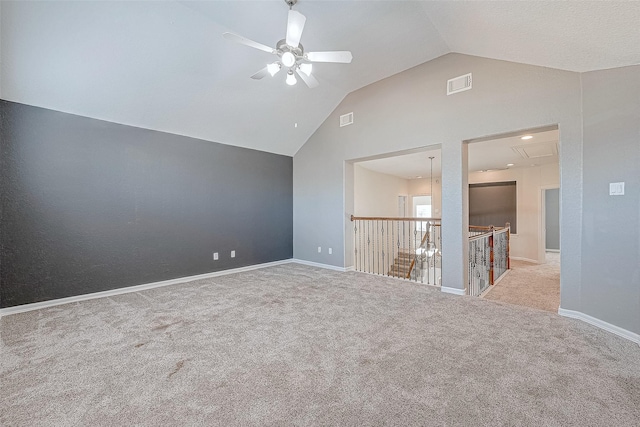 empty room featuring light colored carpet, vaulted ceiling, and ceiling fan