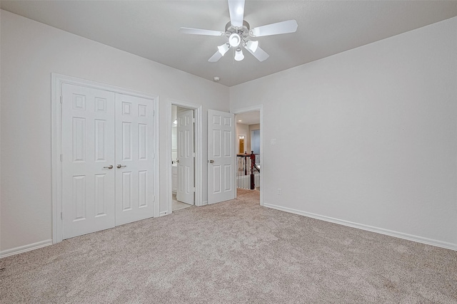 unfurnished bedroom featuring a closet, light colored carpet, and ceiling fan