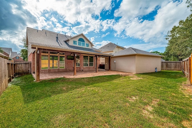 rear view of house featuring a lawn and a patio