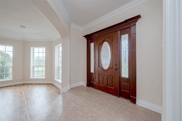 foyer entrance with light hardwood / wood-style floors and ornamental molding