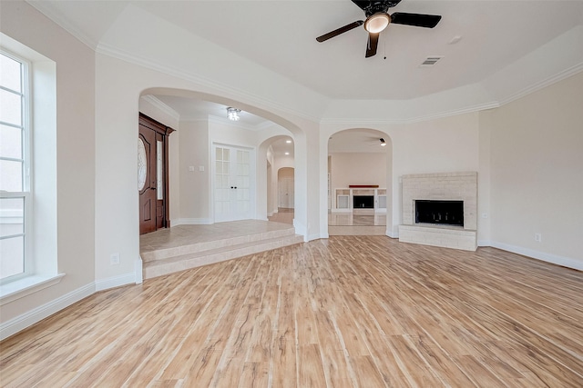 1810 Mccrary Rd, Richmond, TX 77406 - unfurnished living room featuring a ceiling fan, wood finished floors, arched walkways, a fireplace, and baseboards