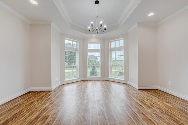 spare room featuring light hardwood / wood-style floors, crown molding, and a notable chandelier