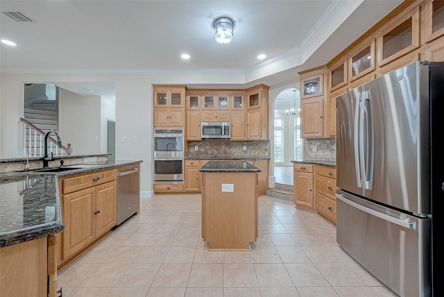 1810 Mccrary Rd, Richmond, TX 77406 - kitchen with stainless steel appliances, a center island, a sink, crown molding, and backsplash