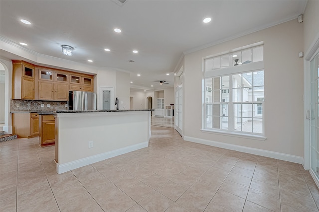 kitchen featuring ceiling fan, backsplash, stainless steel fridge, crown molding, and light tile patterned floors