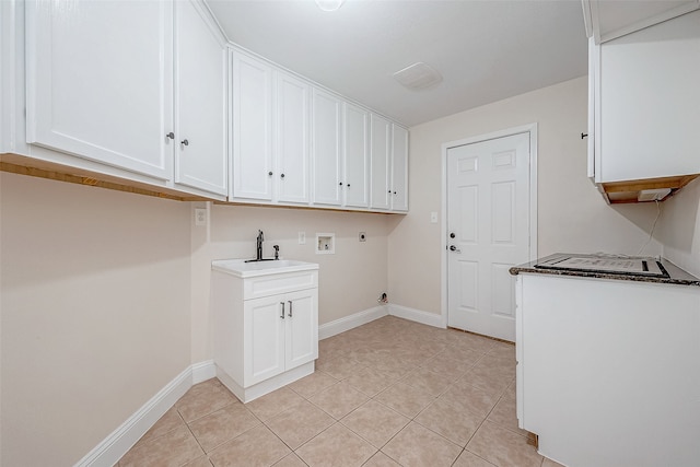 clothes washing area featuring sink, cabinets, washer hookup, hookup for an electric dryer, and light tile patterned floors