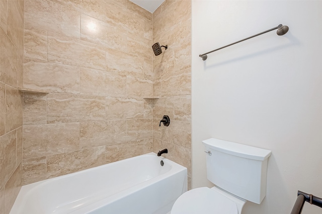 bathroom featuring tiled shower / bath combo and toilet