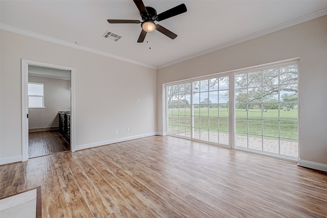 interior space with light hardwood / wood-style floors, plenty of natural light, ornamental molding, and ceiling fan